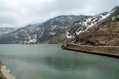 Scenic view of lake and snowcapped mountains against sky