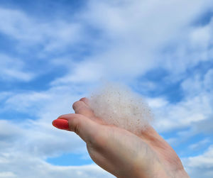 Poplar fluff in his hand against the blue sky. weightlessness, lightness, the concept of allergy.