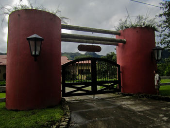 Close-up of metal gate against sky