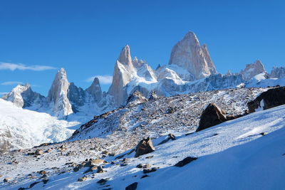 Scenic view of snowcapped mountains against clear blue sky