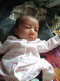 High angle view of cute baby boy looking away while lying on bed at home