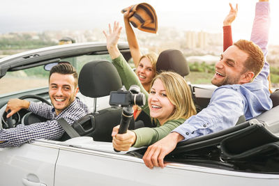 Happy young couple sitting in convertible