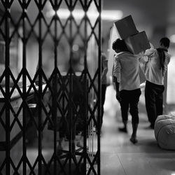 Rear view of men carrying boxes