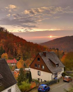 Houses and buildings against sky during sunset