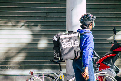 Woman walking on bicycle in city