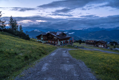 Street amidst buildings and mountains against sky