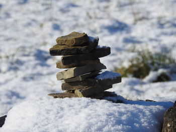 Close-up of stone stack on snow covered field