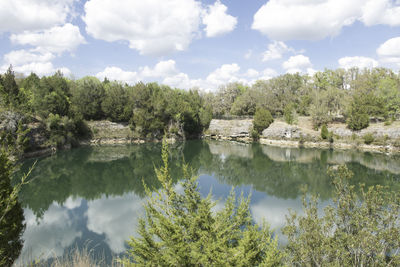 Scenic view of lake by trees against sky