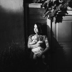 Young woman sitting in front of building