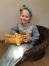 Portrait of smiling girl sitting in basket