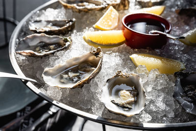 Oysters on metal tray with ice, lemon restaurant menu, dieting, cookbook recipe