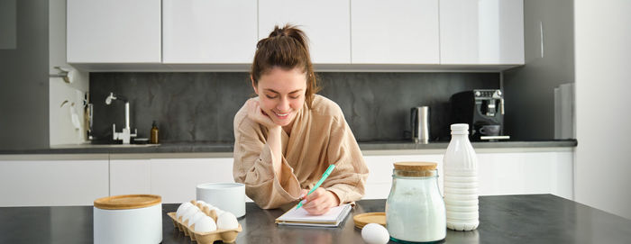 Side view of woman drinking coffee at home