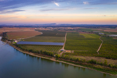 Aerial view of agricultural field against sky during sunset
