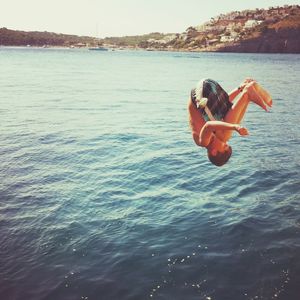 Woman in sea against sky