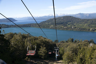 Overhead cable car over lake against sky. cerro campanario chairlift. descent. bariloche, argentina. 