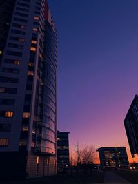 Low angle view of illuminated buildings against sky during sunset