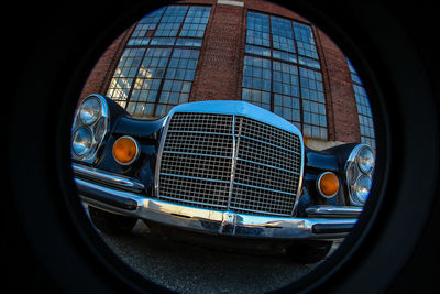 Vintage car against building seen through circle shape window