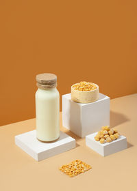 Vegetable pea milk in a bottle and chick peas in bowl on white podium .isometric diagonal projection