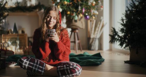 Portrait of young woman sitting on sofa at home