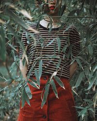 Close-up of woman standing against plants
