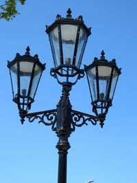 Low angle view of street light against blue sky