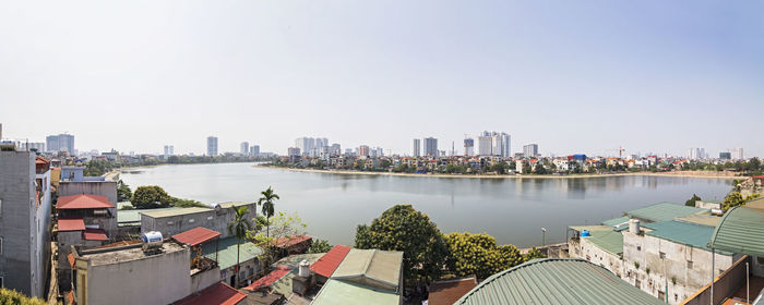 Panoramic view of city by river against clear sky