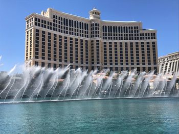 Water fountain in city against clear sky