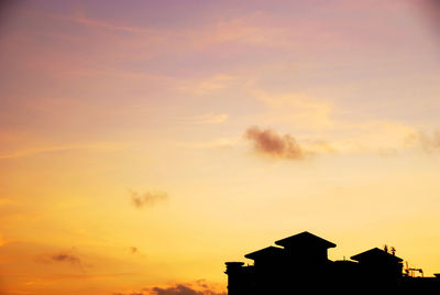 Low angle view of silhouette building against sky during sunset