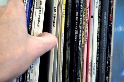 Cropped hand touching books on shelf