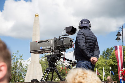 Man photographing against sky