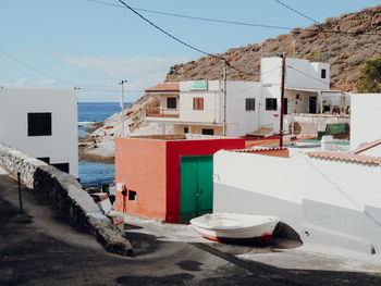 Houses by sea against sky in city