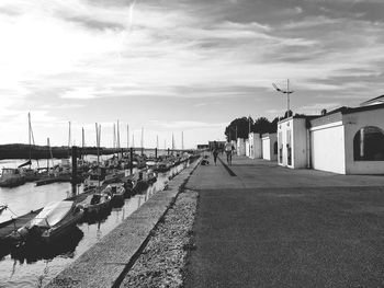 Footpath by sea against sky in city