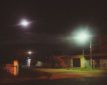 Illuminated street light against sky at night