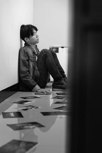 Side view of a young woman sitting on table