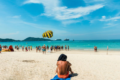 People enjoying at beach against sky