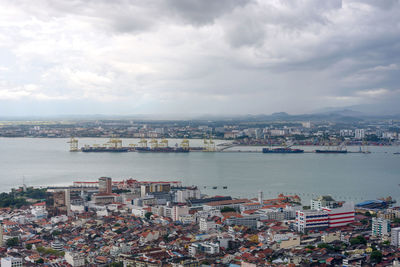 High angle view of townscape by sea against sky