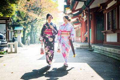 Women walking on footpath in city
