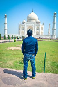 Rear view of man standing in front of building