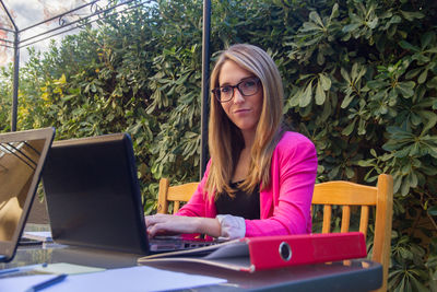 Portrait of woman using laptop at cafe