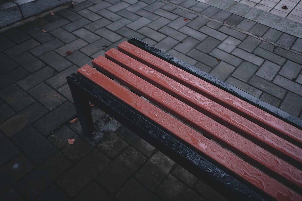 HIGH ANGLE VIEW OF BENCH ON SIDEWALK