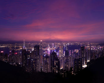 Illuminated buildings in city against sky at night