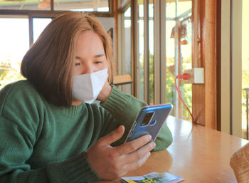 Portrait of young woman using mobile phone