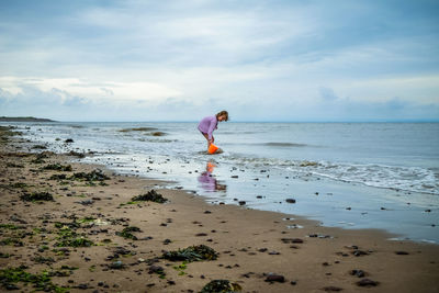 Girls playing on the beach with bucket and spade 