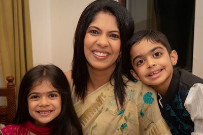 Portrait of smiling mother with daughter and son at home