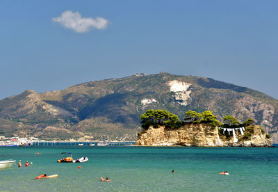 Scenic view of sea and mountains against clear sky