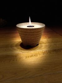 Close-up of illuminated candle on table