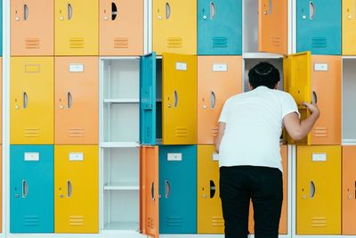 Rear view of man checking locker