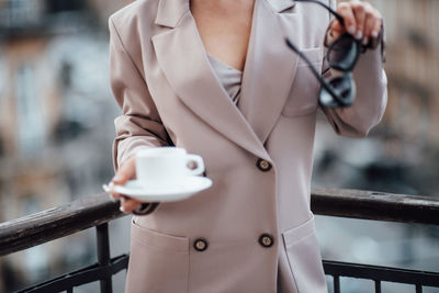 Midsection of woman holding coffee cup