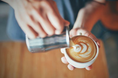 Close-up of hand holding coffee cup