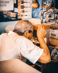 Rear view of man sitting on floor